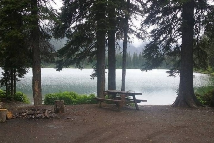 an empty park bench next to a body of water